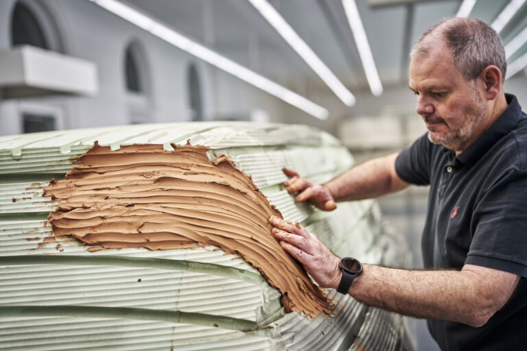 Mick Allbutt applies a layer of clay.