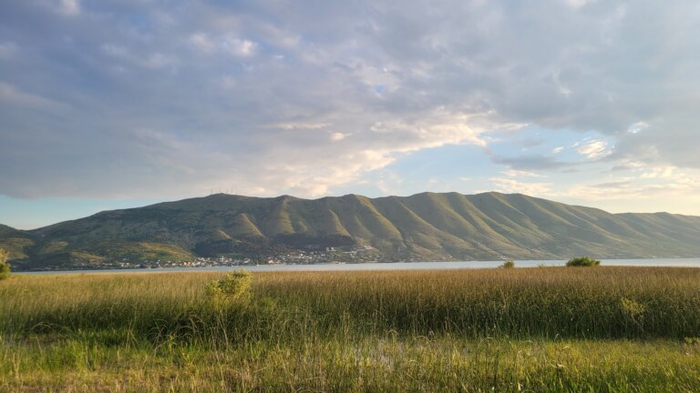 Lake Shkodra is surrounded by mountains on one side.