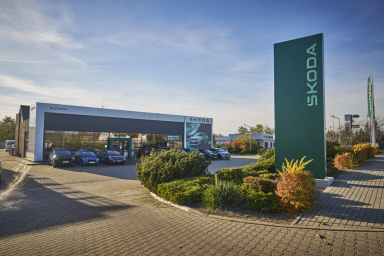 Škoda cars are lined up in front of the modern building as well as inside it.
